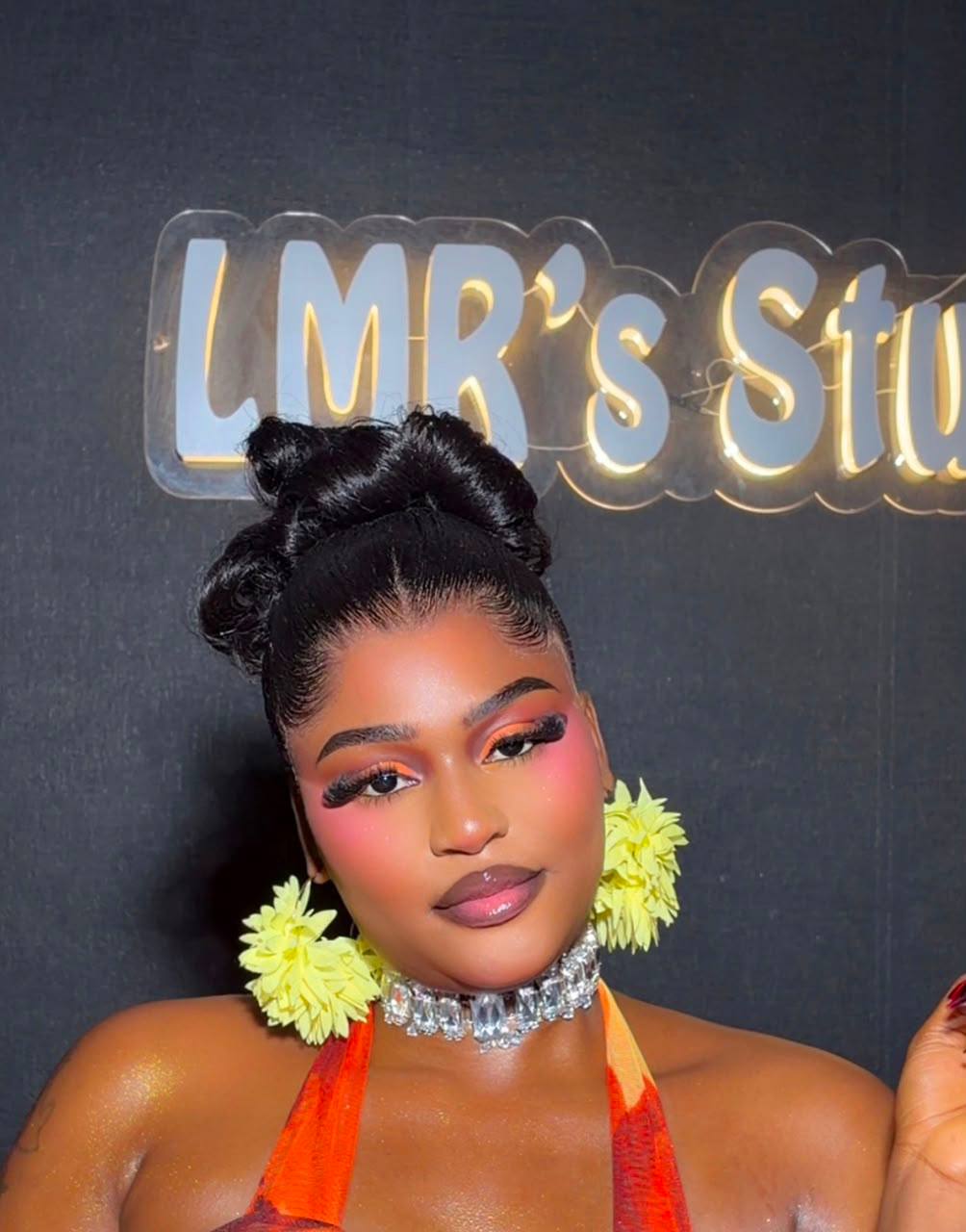 LMR Studio client wearing orange-toned glam makeup and yellow floral earrings