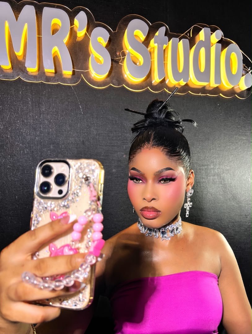 Client taking a mirror selfie in a magenta dress and full glam makeup